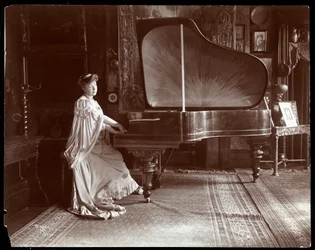 Mrs. I. M. Clark, an einem Konzertflügel sitzend, 1904